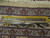 Ruler across border measuring knots per square inch on this hand-knotted 9x13 Persian Kashan rug