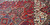 Deep red field with serrated leaf motifs meeting ivory corner spandrel on this Persian rug