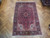 7x10 red Heriz Persian rug photographed overhead on herringbone parquet floor showing full medallion design