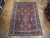 7'5" x 10'9" Persian Heriz rug displayed on parquet floor in Freeport showroom