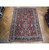 Semi-antique 8 x 11 Persian wool rug photographed from above on showroom parquet flooring