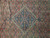 Close-up of the navy blue stepped medallion framed in ivory against dense coral Herati lattice