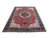 Angled 8x11 Tabriz rug photo showing coral red field, navy floral border and ivory fringe