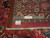 Back of the 10x13 Tabriz rug folded beside a ruler showing hand-knotted cotton foundation