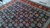 Large navy 10x13 Tabriz rug laid on concrete floor, dense floral repeat clearly visible