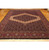 Large hand-knotted wool rug displayed on parquet flooring, ivory medallion centered on dark patterned ground