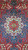 Close detail of ivory and navy central medallion with red rosette and turquoise floral accents