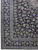 Corner detail showing light blue and ivory floral borders framing the navy Kashan field