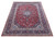 Angled floor view showing 10x13 Kashan rug, deep navy border and dense red floral field