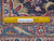 Back of the hand-knotted wool rug with ruler showing knot count per square inch