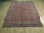 Angled floor view of hand-knotted wool Bijar rug with ivory fringe and geometric lattice field