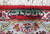 Woven signature cartouche in green and ivory along the end border of this Persian rug