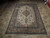 6'6" x 10' Persian Kashan rug displayed on stone tile floor showing full medallion layout