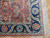 Corner detail showing navy border rosettes, ivory guard band, coral selvage and cream cotton fringe