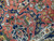 Close-up macro of coral field palmettes, navy vine work and green leaves in dense wool