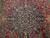 Close-up of ivory and navy lobed medallion with blue palmettes on deep red wool pile