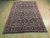 7x10 Persian Bijar rug seen at an angle, ivory fringe and repeating palmette field visible
