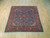 Angled view of 7x7 square Persian rug showing dense floral field and rose border