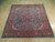 Full perspective of blue Persian wool rug with ivory corner spandrels and salmon main border