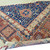 Close view of indigo corner panel, star medallion and compartmented salmon border in wool pile