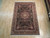 5'10" x 8'10" hand-knotted Oriental rug shown flat on light hardwood showroom flooring