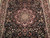 Close-up of lobed burgundy medallion, rose and palmette florals on deep black wool field