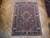 6'8" x 9'7" Persian Heriz rug displayed on herringbone parquet floor showing red field and navy border