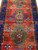 Close view of three tribal medallions in green, blue and gold with diamond rosette centers
