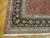 Corner detail showing black border, ice blue guard stripes, rose palmettes and hand-knotted wool pile