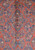 Close-up of central lozenge medallion with navy and sky blue blossoms on salmon wool