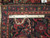 Back of the 7x11 Heriz rug beside a ruler showing hand-knotted wool knot density