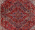Close-up of the stepped geometric medallion with salmon and navy palmettes on deep red