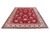 9'9" x 13'3" Tabriz rug photographed at an angle showing ivory main border and red field