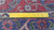 Reverse of the rug with a ruler across the weave, showing knot rows and cotton foundation