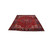 Red Heriz rug photographed at floor angle showing navy rosette border and ivory corner spandrels