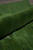 Rolled edge close-up showing plush wool pile depth and moss to pine green shading