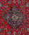 Close-up of navy lobed diamond medallion with ivory cartouche on rich red Persian field