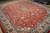 Angled view of the wool pile showing brick red field, blue vines and ivory main border