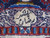 Woven cartouche signature in ivory wool on the upper border of this signed Kashmar rug