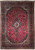 Ruby red Persian Kashan rug with navy floral border, ivory spandrels and central lobed medallion