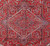 Stepped diamond medallion with rosette center and angular vines on brick red Heriz field