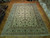 9'10" x 13'9" Kashan rug shown flat on parquet floor in a gallery showroom