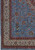 Corner detail showing pink, olive and burgundy palmettes on the sky blue field beside ivory guard borders