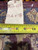 Inventory tag and tape measure resting on the rug's back showing fine knot density