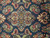 Close-up of the diamond medallion with coral, teal and ivory palmettes on deep navy wool pile