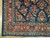 Corner detail showing rose red main border, teal guard stripes and dense floral knotting