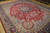 Angled view showing multicolor floral field, light blue corner medallions and deep navy scrolling border
