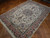 7x10 Persian Tabriz rug angled on parquet, rose-pink borders framing a dense ivory floral field