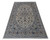 Angled studio photo of ivory living room rug with sapphire blue borders and cream fringe