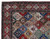 Corner detail of ivory and red borders framing hand-knotted floral panels on this Persian wool rug